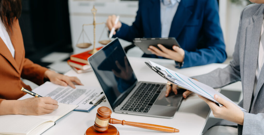 A female lawyer using a laptop during a law firm meeting